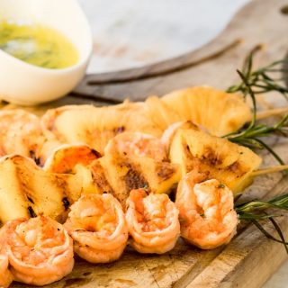 Shrimp On Rosemary Skewers with a serving sauce.