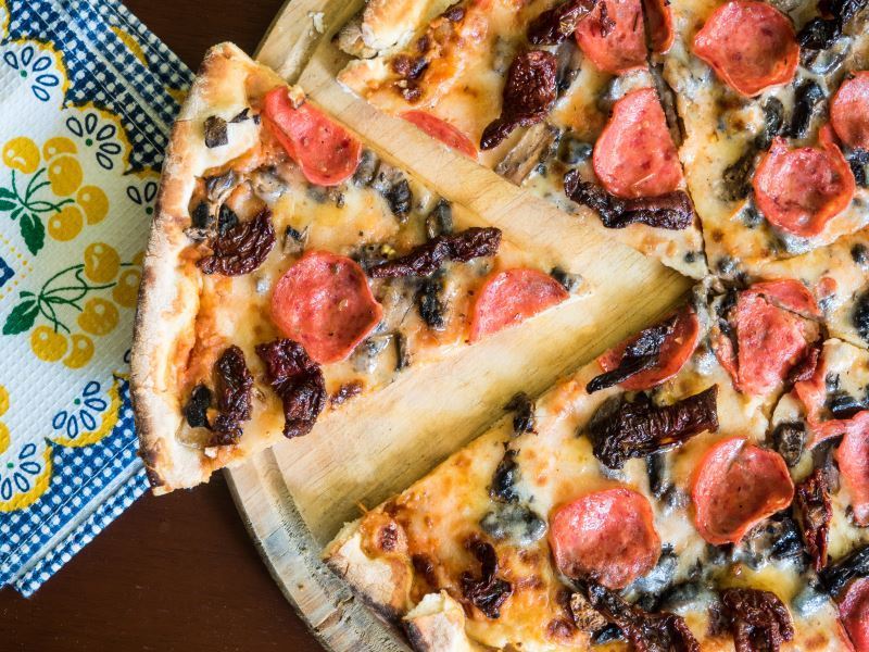 Pepperoni pizza on a cutting board.