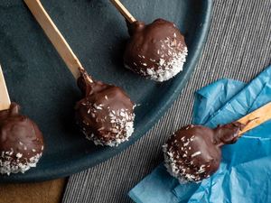 Cheesecake Cake Pops Coated in Dark Chocolate & Coconut Flakes recipe image. inthekitch.net