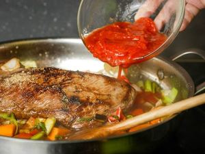 How to Braise Beef - Step 7 image, pouring tomato sauce in pan. inthekitch.net