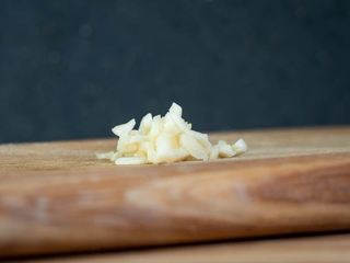 How to Chop Garlic - Step 6 image, chopped garlic on a wooden cutting board. inthekitch.net