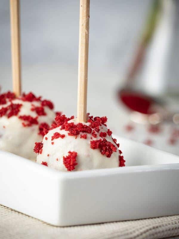 Red Velvet & White Chocolate Cake Pops in white rectangular serving dish. inthekitch.net