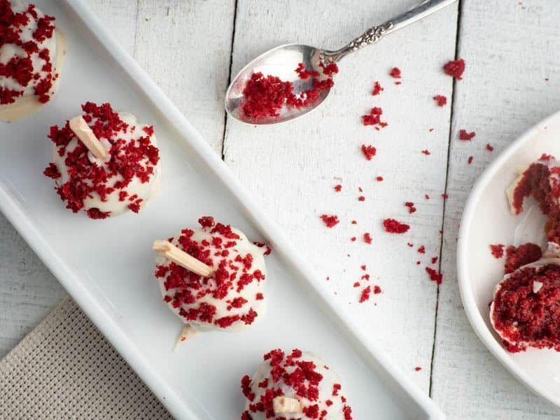 Red Velvet & White Chocolate Cake Pops in white rectangular serving dish. inthekitch.net