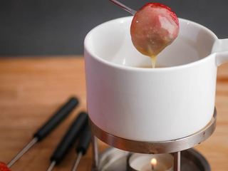 How to Make White Chocolate Ganache - Step 5 image of white chocolate ganache fondue pot dipping with a strawberry - inthekitch.net