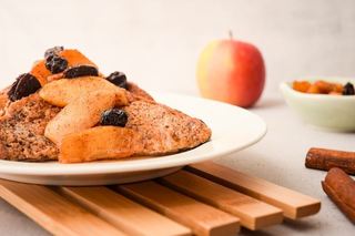French Toast with Cinnamon Apple Garnish on a plate, on wood rack.