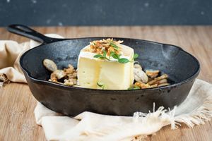 Brie in a cast iron pan with mushrooms oregano walnuts and honey.