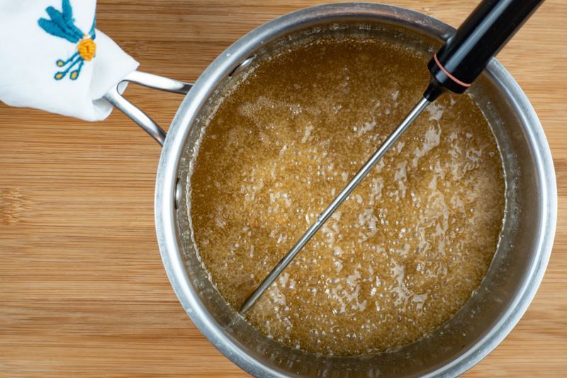 Heating sugar mix in pot and using a candy thermometer.