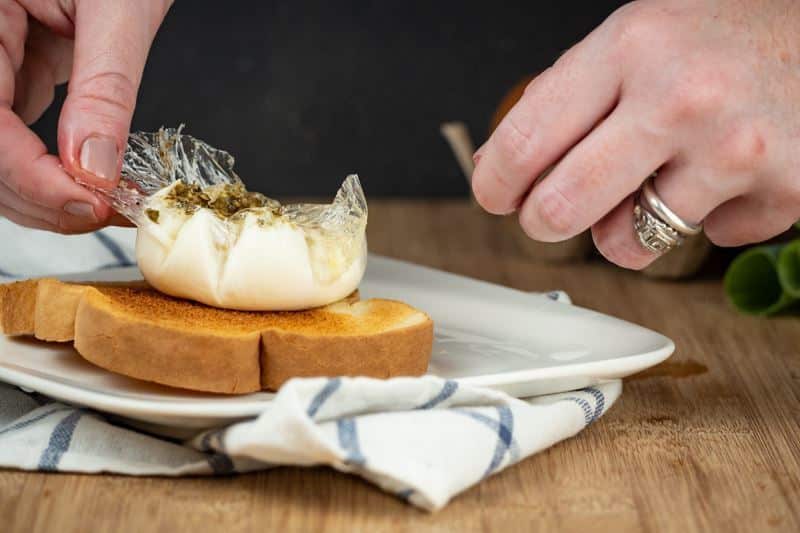 How to Sous Vide Eggs Step 10 Poached - opening egg pouch over toast.