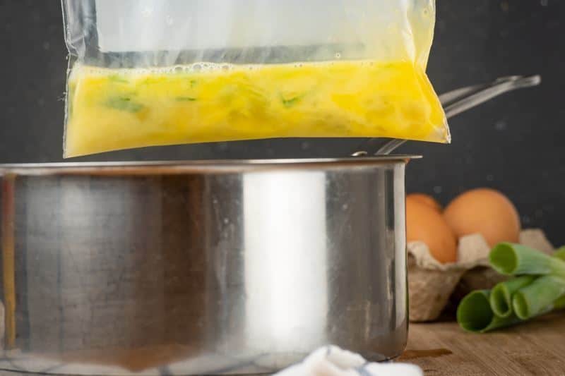 How to Sous Vide Eggs Step 3 Scrambled - placing scrambled egg plastic bag into pot.
