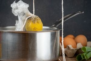 How to Sous Vide Eggs Step 8 Poached - dipping egg pouch into pot of boiling water.