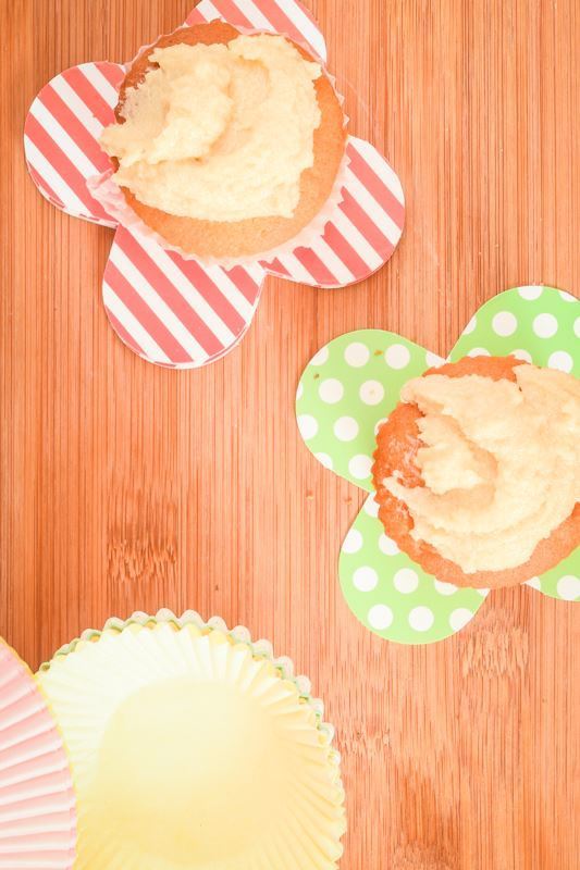How to Make Buttercream Final 2 Frosted cupcakes on wooden counter.