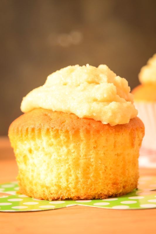 How to Make Buttercream Final 4 Frosted cupcakes on wooden counter.