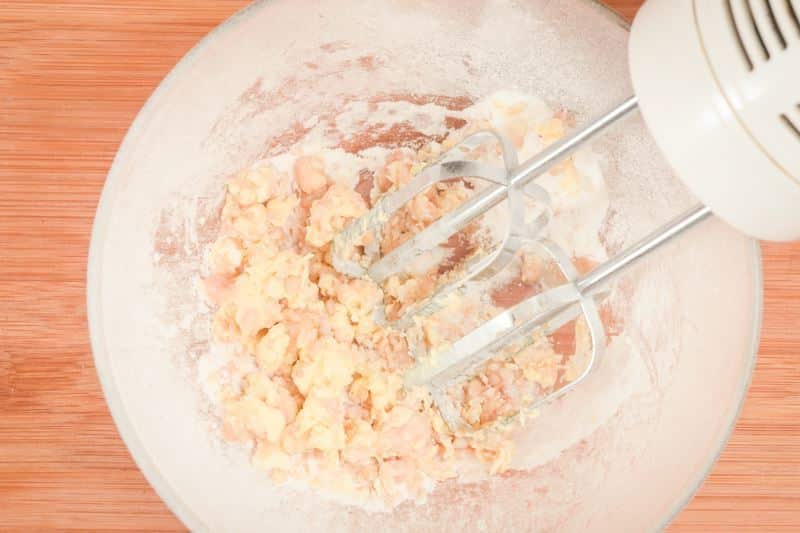 How to Make Buttercream Step 3 Using a hand mixer to combine vanilla, butter and sugar.