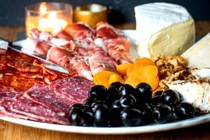 Finished Charcuterie Board with meat, cheese, olives and apricots.