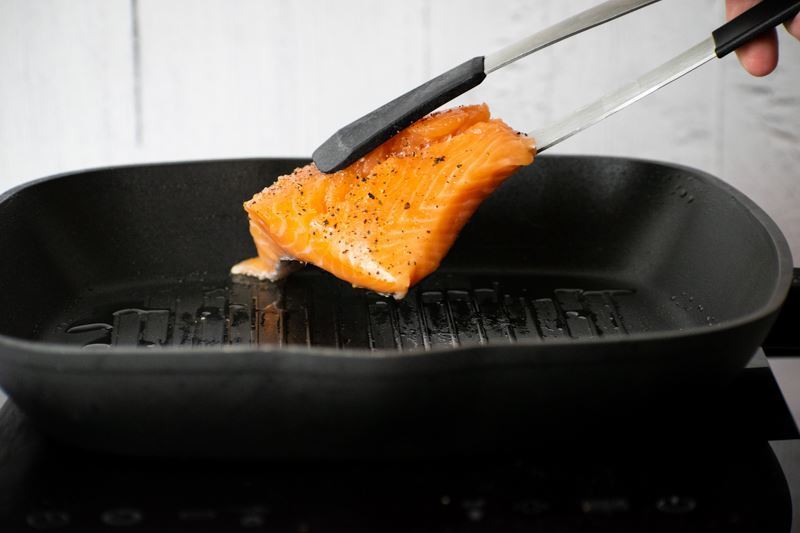How to Cook Salmon With Skin Step 4 Adding raw salmon to pan, skin side down.