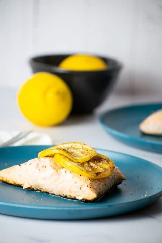 How to Cook Salmon With Skin Step 8-4 Cooked salmon with grilled lemon slice on plate.
