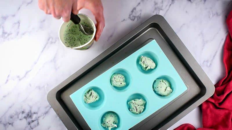 Scooped out ice cream balls into silicone mold on pan.