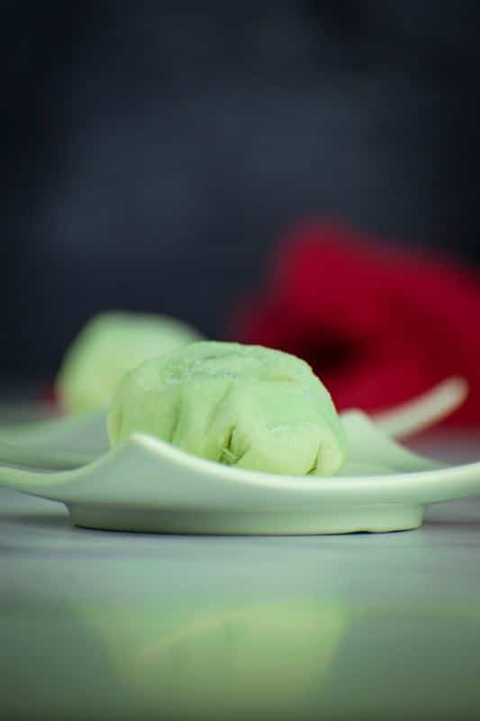 Mint green mochi ice cream on a mint-colored dish.