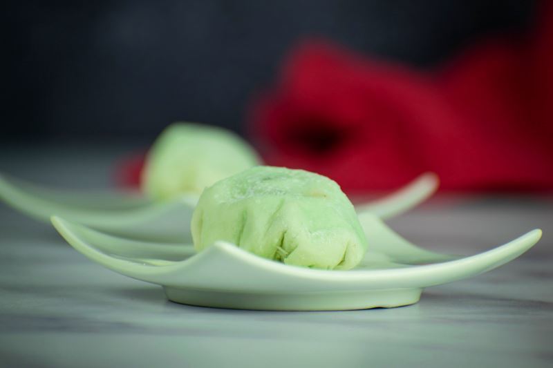 Mint green mochi ice cream on a mint-colored dish.