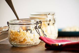 A jar of ricotta cheese on the counter.
