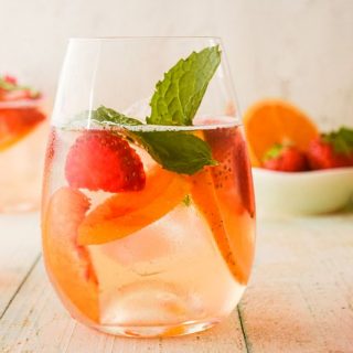 Wine glass filled with white wine sangria and mint leaves.