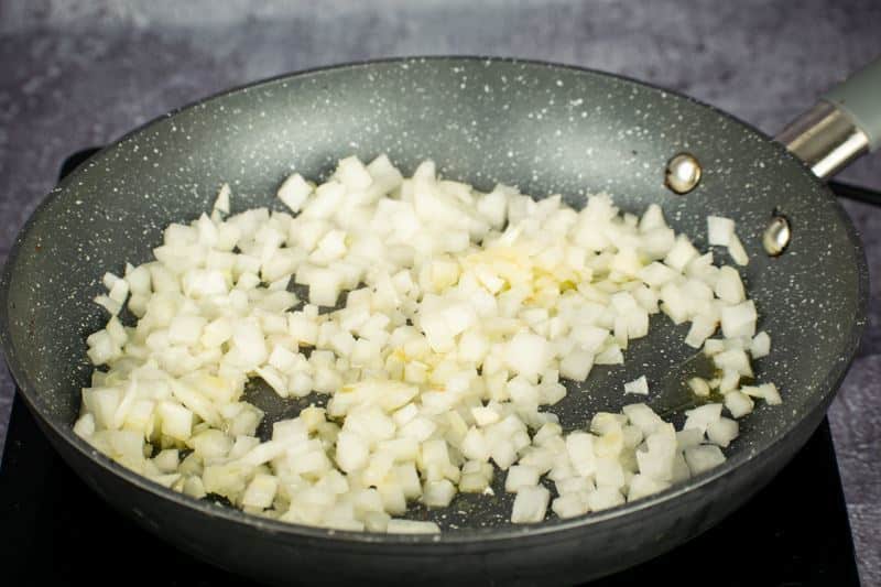 Chopped onions cooking in a pan.