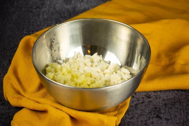 How to Make Pierogies Step 4-2 Cheese and mashed potato in a bowl, yellow dish cloth underneath.