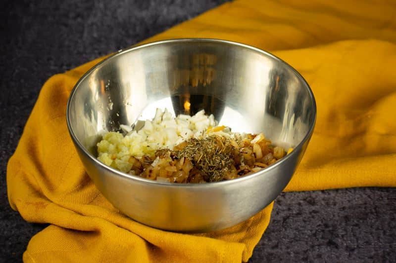 How to Make Pierogies Step 4-5 Cheeses, spices, potato and onions in a bowl, yellow dish cloth underneath.