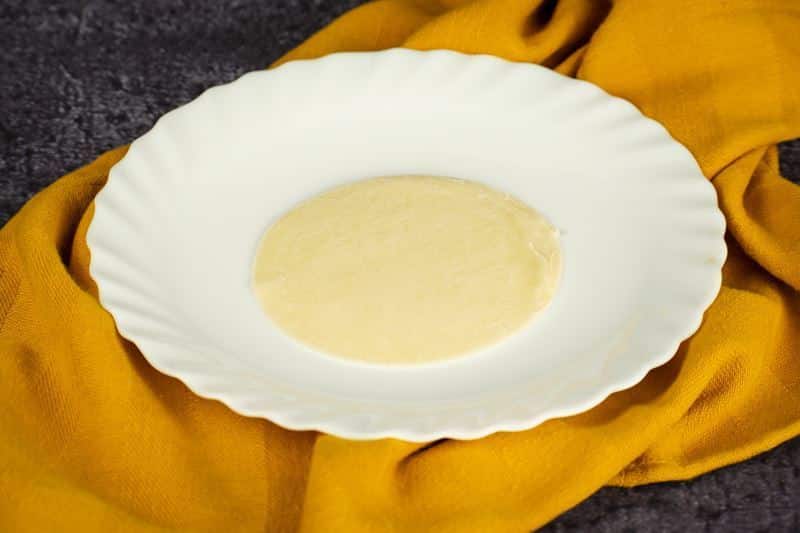 Pierogi disc on a plate, yellow dish cloth underneath.