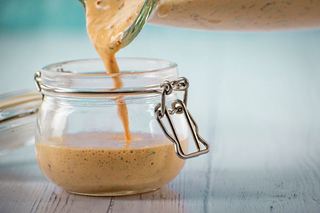Chipotle sauce pouring into a jar.