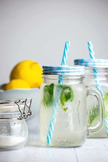 Decorative mason jars with lemonade and basil.