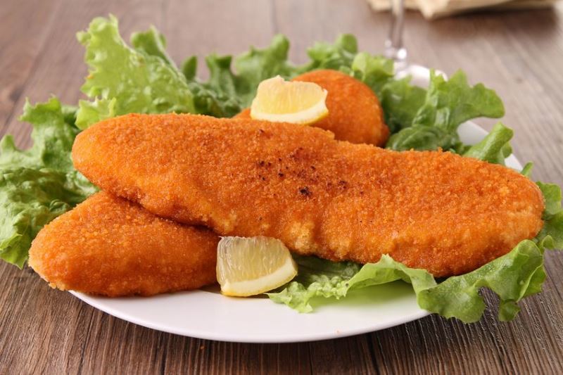 Fried fish on a plate with lemon.