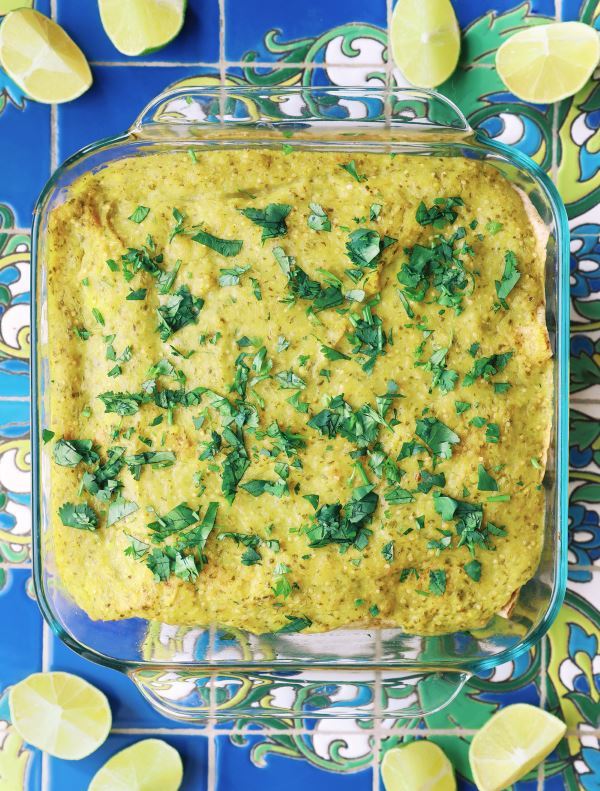 enchilada1 Potato & Black bean enchiladas in a glass dish with tomatillo sauce.
