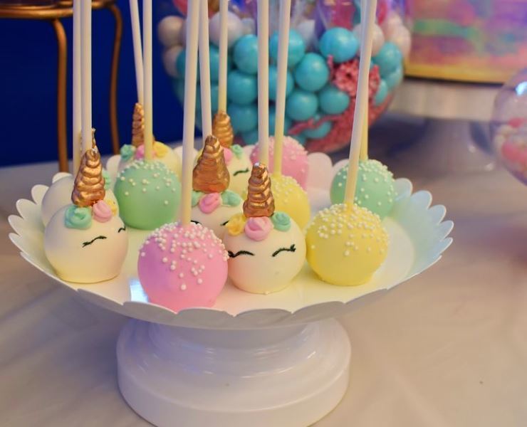 Unicorn cake pops on a white tray.