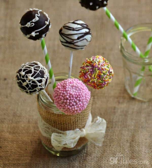 Gluten free cake pops in stand, frosted in sprinkled in different colors.