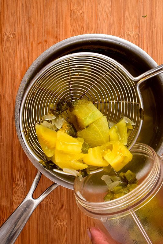 How to Make Tomatillo Salsa_8 Cooked tomatillo salsa ingredients being transferred to a blender jar.
