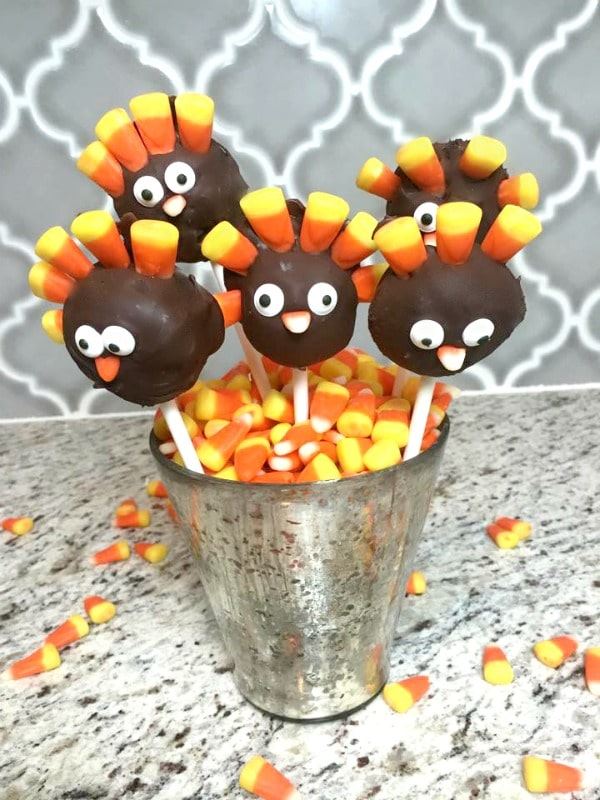 Turkey oreo cake pops in a small pail with candy corn.