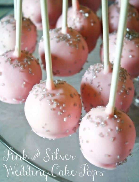 Pink cake pops with silver sprinkles.