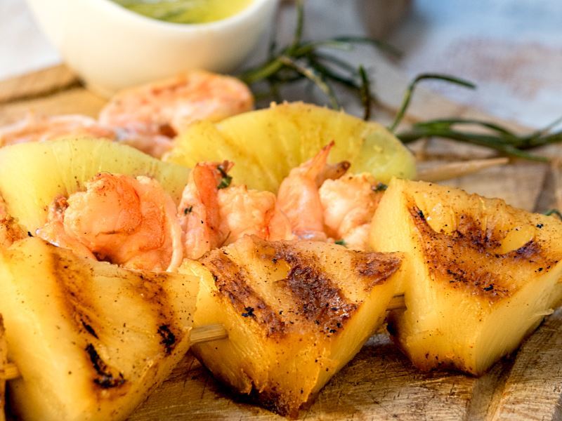 Shrimp on Rosemary Skewers with Rum-Soaked Pineapple wedges.
