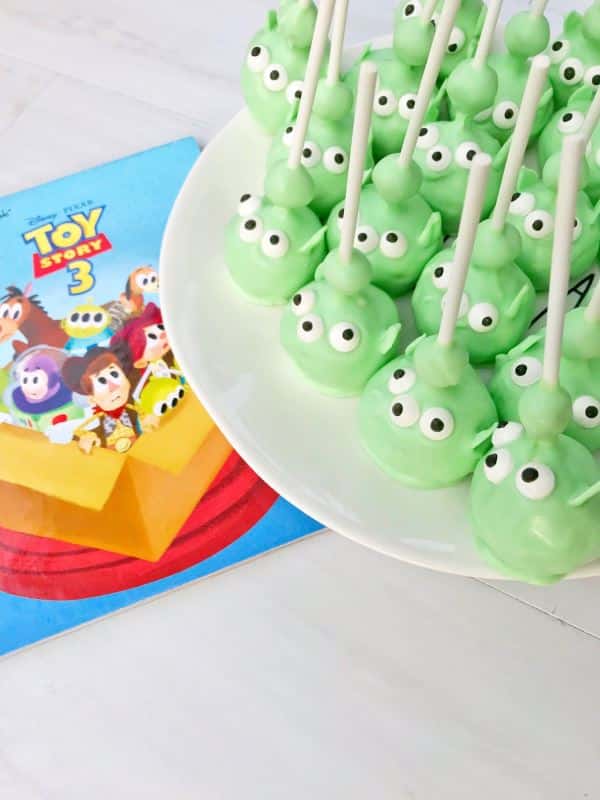 Alien cake pops on a plate, toy story napkin underneath.