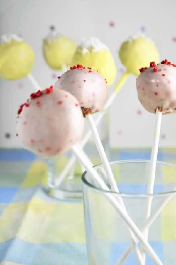Raw cake pops decorated in white and yellow chocolate and sprinkles.