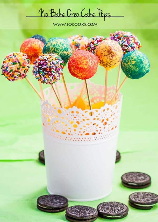 Colorful no bake oreo cake pops in a white stand.