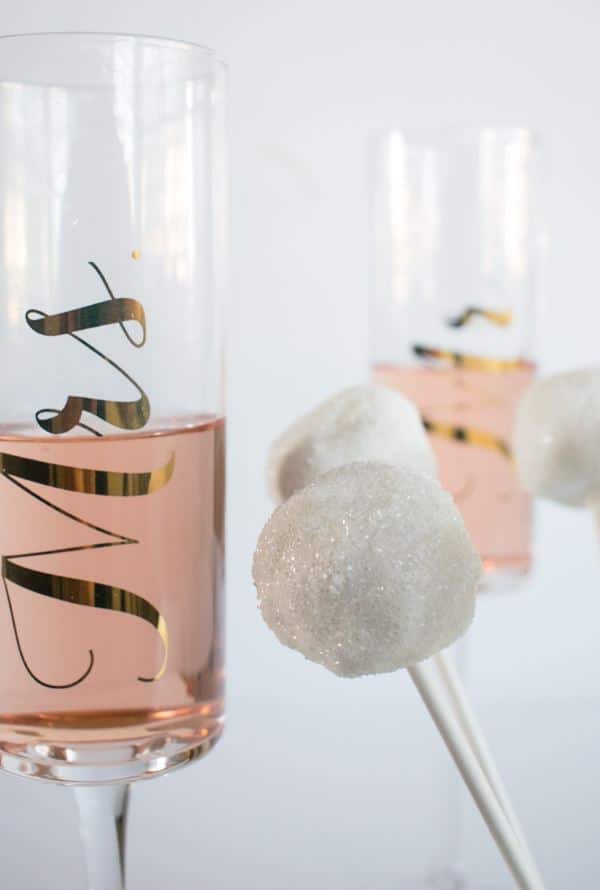 White cake pops with sparkles and Mr. and Mrs. Champagne glasses.