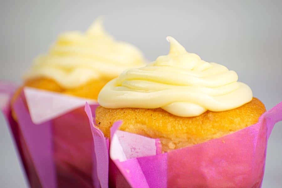Butter Cream_4 2 cupcakes with buttercream frosting in purple wrappers.
