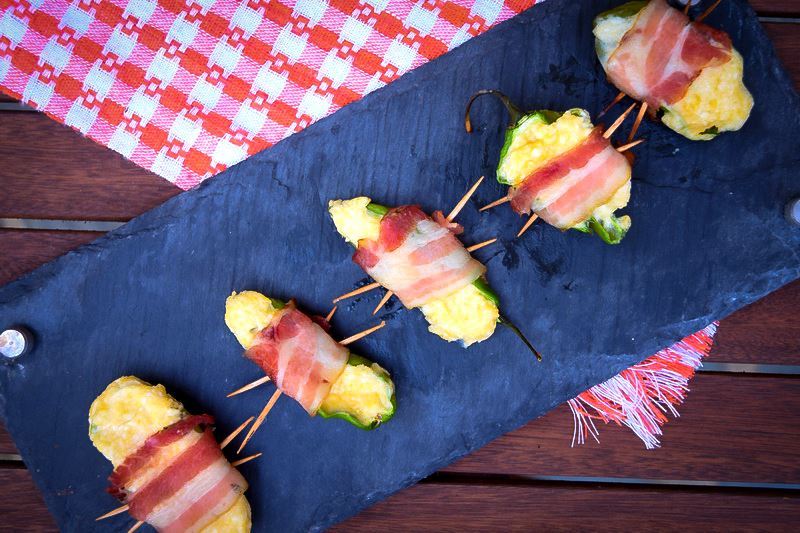 How to Grill Jalapeño Poppers_15 Grilled jalapeno poppers on a black rectangular serving tray.