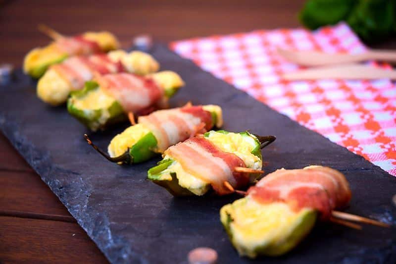How to Grill Jalapeño Poppers_16 Grilled jalapeno poppers on a black rectangular serving tray.