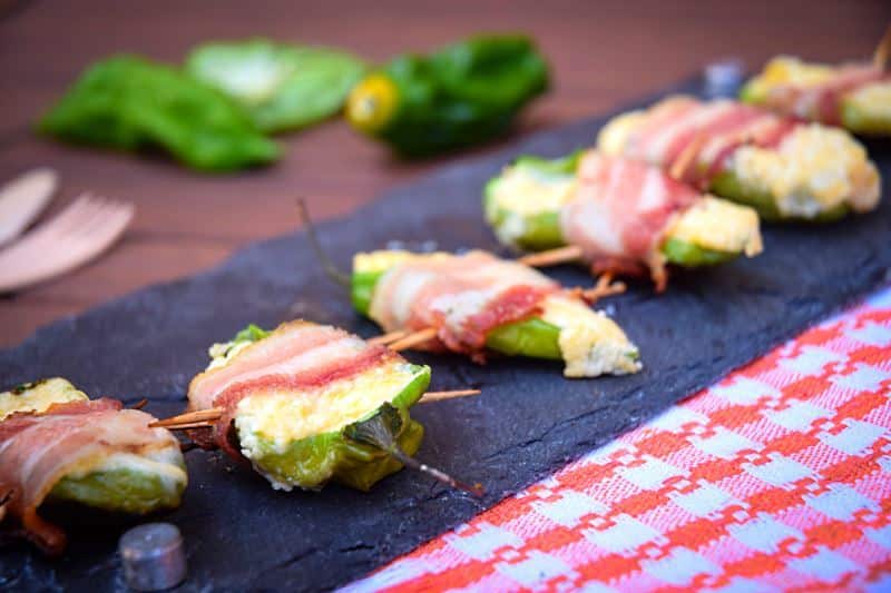 How to Grill Jalapeño Poppers_17 Grilled jalapeno poppers on a black rectangular serving tray.