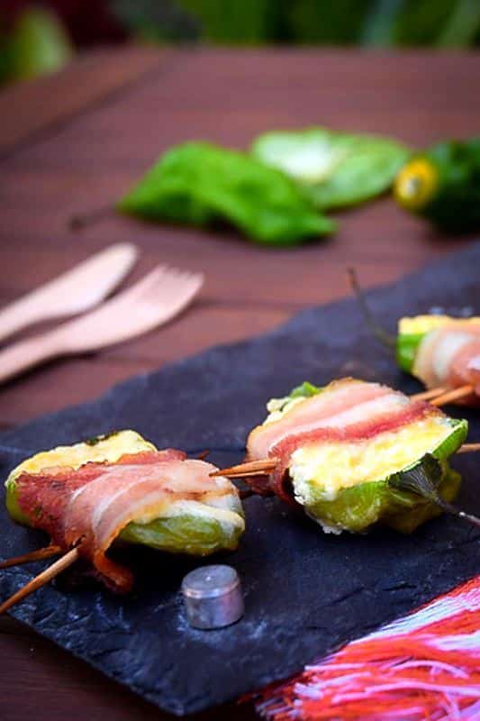 How to Grill Jalapeño Poppers_18 Grilled jalapeno poppers on a black rectangular serving tray.