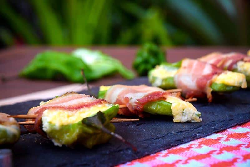How to Grill Jalapeño Poppers_19 Grilled jalapeno poppers on a black rectangular serving tray.
