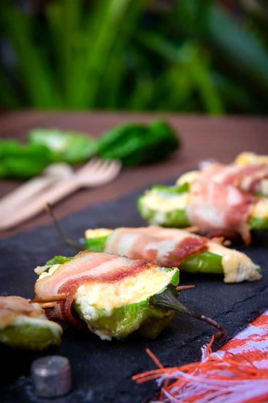 How to Grill Jalapeño Poppers_20 Grilled jalapeno poppers on a black rectangular serving tray.